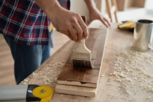 Applying a protective finish to a wood board with a brush